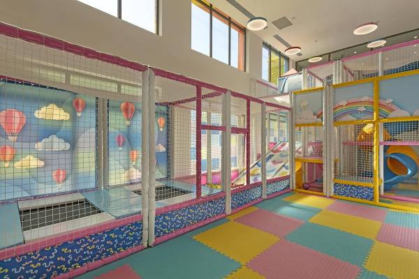 Kinderspielplatz im Cullinan Belek Hotel mit bunten Farben, Trampolinbereich und Kletterwand.