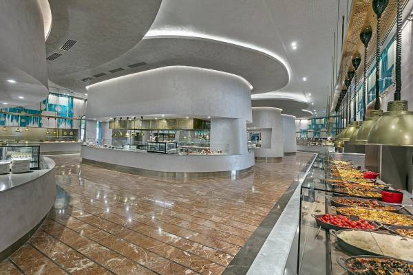 Innenansicht des Restaurants im Cullinan Belek Hotel mit Marmorboden und offenen Küchenbereichen.
