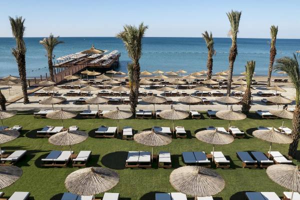 Luftaufnahme des Cullinan Belek Hotels mit Sonnenliegen und Sonnenschirmen am Strand