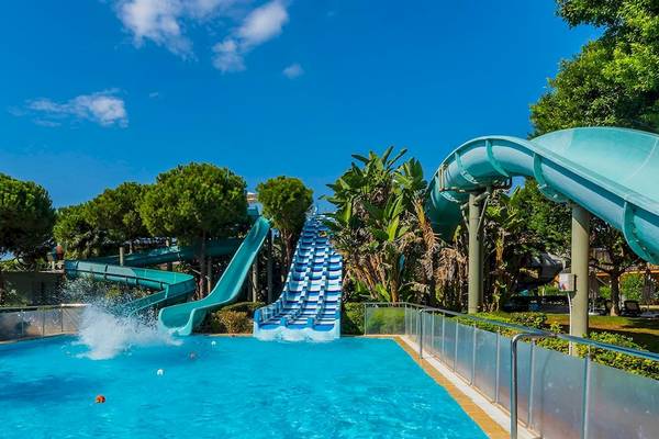 Wasserrutsche im Gloria Serenity Resort Hotel mit blauem Pool und blauem Himmel