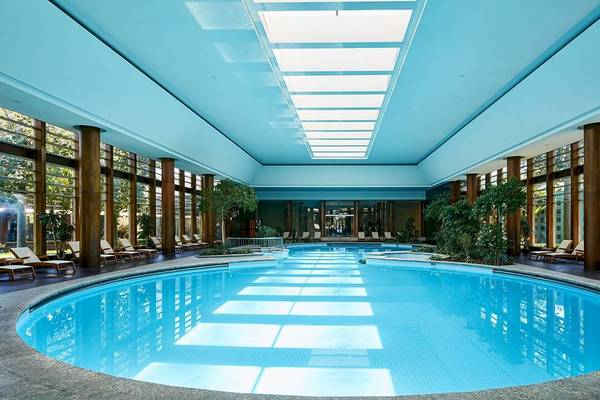 Innenpool im Gloria Serenity Resort mit blauer Decke und Glaswänden.