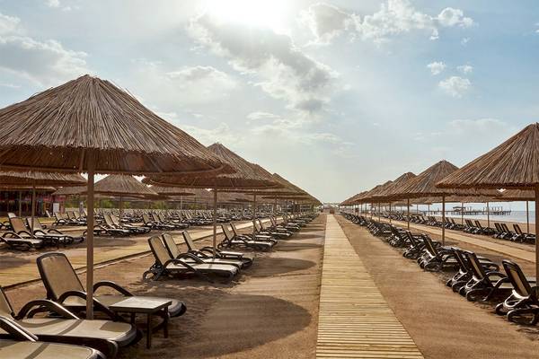 Strand des Gloria Serenity Resort mit vielen Liegestühlen und Sonnenschirmen
