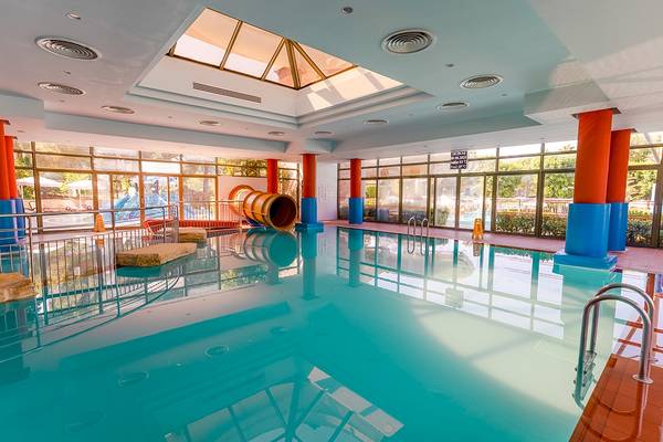 Innenpool des Gloria Serenity Resorts mit Rutsche und Glaswänden