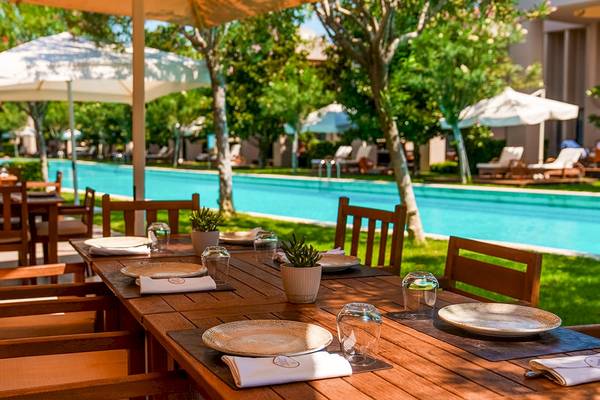 Glorious Serenity Resort Pool Dining Tisch mit Sonnenschirmen und Pflanzen