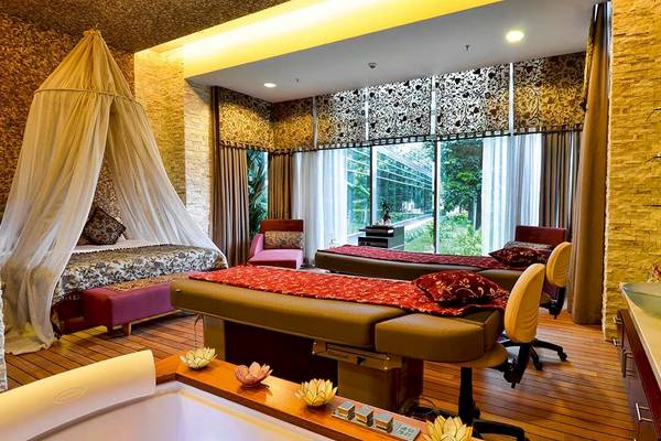 Spa-Zimmer im Gloria Serenity Resort mit zwei Massagetischen, einem Bett und einer Badewanne.