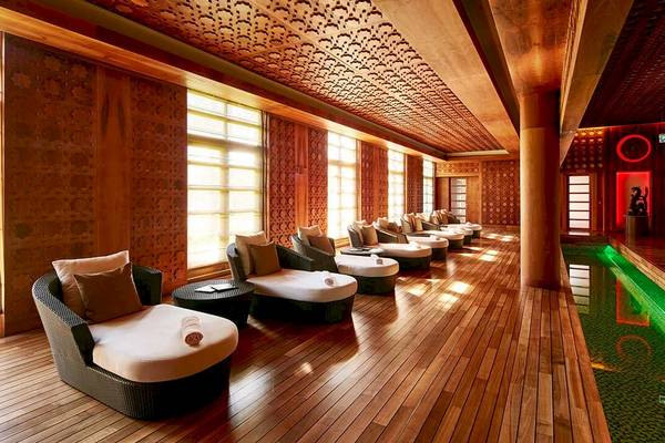 Spa-Lounge im Gloria Serenity Resort mit gepolsterten Sesseln und einem Pool.