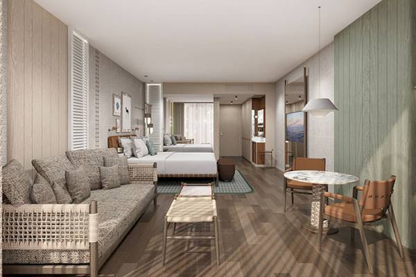 Innenansicht einer Suite im Gloria Serenity Resort mit Wohnzimmer, Schlafbereich und Tisch.