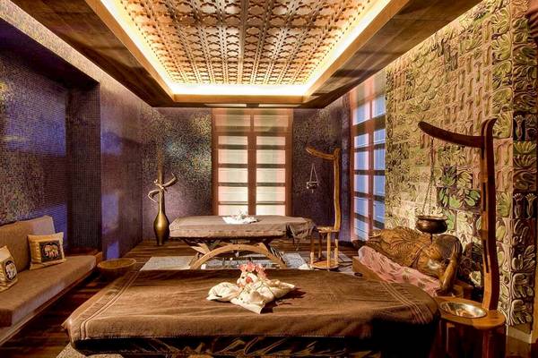 Massageraum im Gloria Serenity Resort mit zwei Massagetischen und dekorativen Elementen.