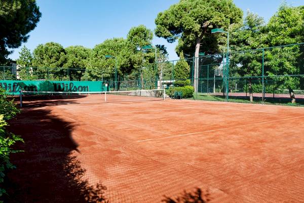 Tennisplatz im Gloria Serenity Resort mit Wilson-Werbetafeln.