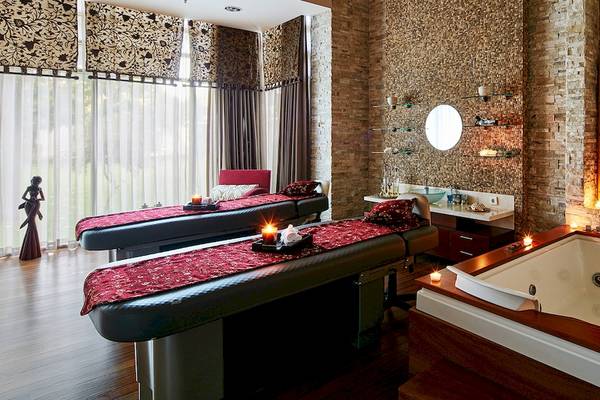 Spa-Behandlungsraum im Gloria Serenity Resort mit zwei Behandlungstischen und einer Badewanne.