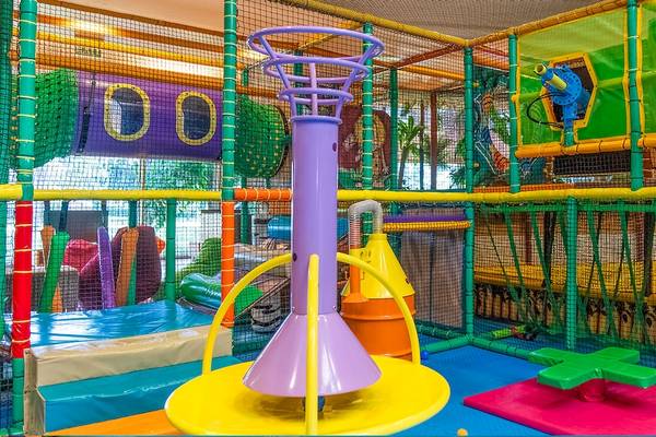 Kinderspielplatz im Gloria Serenity Resort mit bunten Spielgeräten und Netzen.