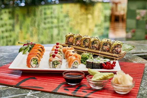 Sushi-Platte auf einem Tisch im Gloria Golf Resort mit Sojasauce und Beilagen.