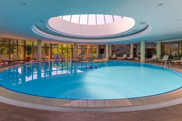 Innenpool des Gloria Golf Resorts mit Loungestühlen und Glaswänden