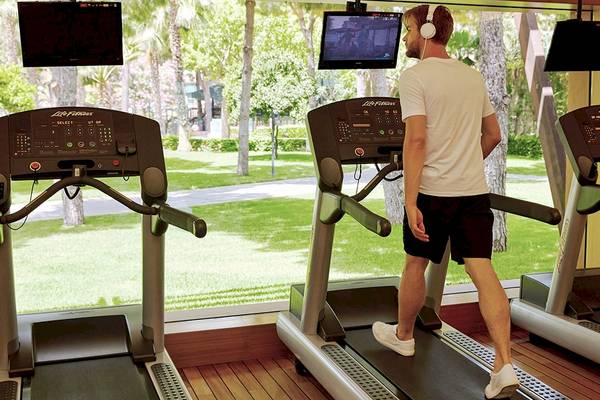 Mann im Gloria Golf Resort Fitnessstudio, der auf einem Laufband läuft