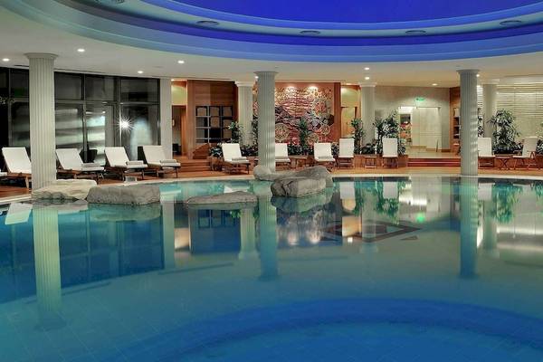 Pool im Gloria Golf Resort mit blauen Fliesen und Lounge-Sesseln.