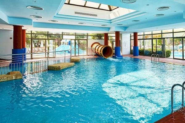 Innenpool des Gloria Golf Resorts mit Rutsche und blauen Säulen