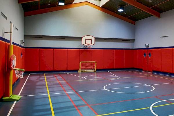 Basketball-Spielplatz im Gloria Golf Resort mit roten Wänden und einem gelben Tor.