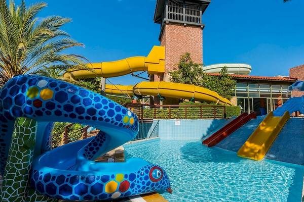 Wasserrutschen im Gloria Golf Resort mit gelber und blauer Rutsche vor einem Gebäude