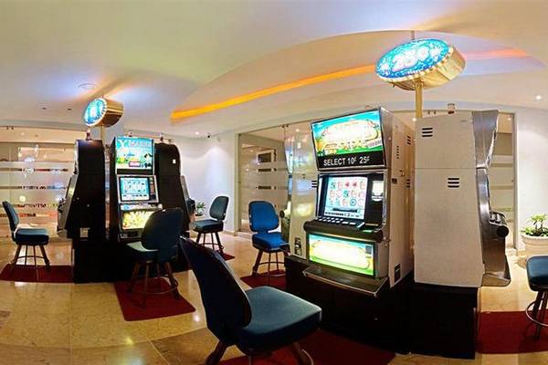 Spielhalle im Iberostar Selection Rose Hall Suites Hotel mit Spielautomaten und Stühlen.