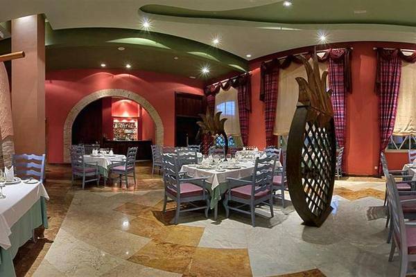 Innenansicht des Restaurants im Iberostar Selection Rose Hall Suites Hotel mit gedeckten Tischen und Stühlen.