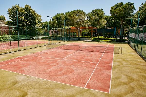 Tennisplatz im Gloria Golf Resort mit roten Belägen und grünen Zäunen.