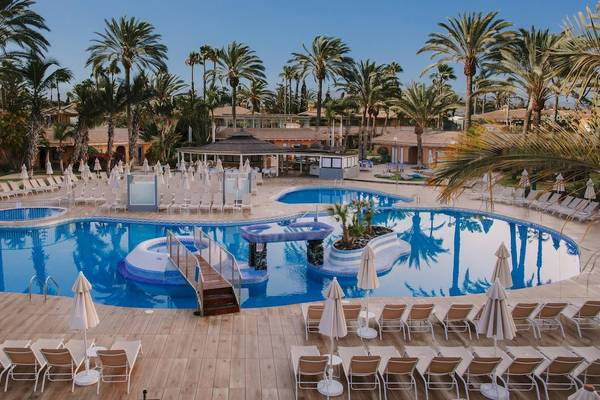 Außenpool des Suites & Villas By Dunas Hotels mit Lounge-Stühlen und Sonnenschirmen.