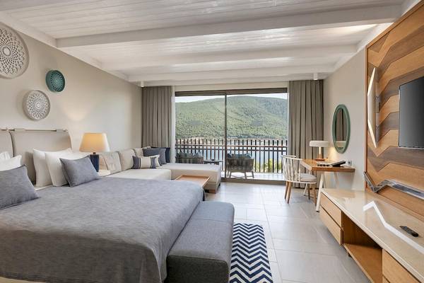 Ein elegantes Zimmer im Titanic Luxury Collection Bodrum mit Blick auf das Meer und Berge.