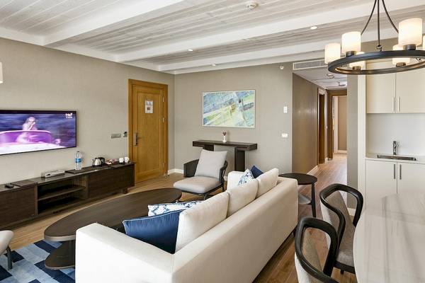 Wohnzimmer des Titanic Luxury Collection Bodrum Hotels mit Fernseher, Möbeln und Dekor.