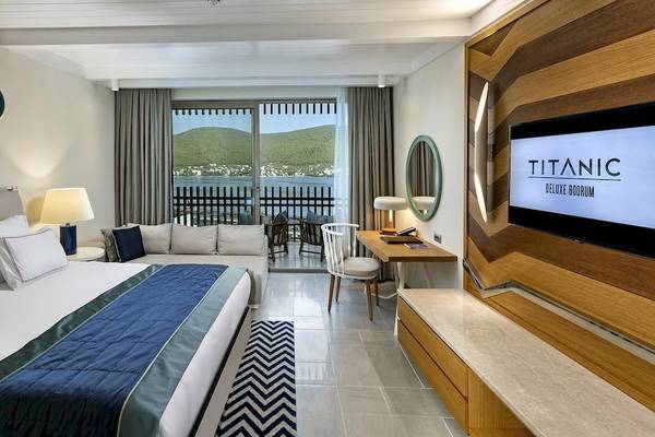 Luxus Suite im Titanic Luxury Collection Bodrum mit Blick auf das Meer und eine Terrasse.
