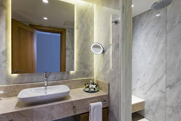 Badezimmer des Titanic Luxury Collection Bodrum Hotels mit Waschbecken, Spiegel und Dusche