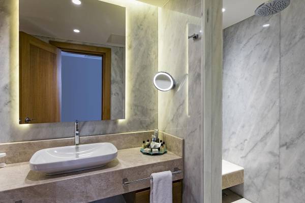 Badezimmer im Titanic Luxury Collection Bodrum Hotel mit Waschbecken, Spiegel und Dusche.