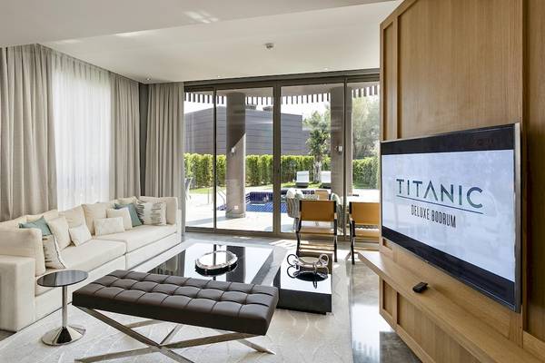 Wohnzimmer mit Sofa und Fernseher im Hotel Titanic Luxury Collection Bodrum.