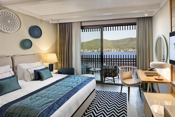 Hotelzimmer im Titanic Luxury Collection Bodrum mit Meerblick, Bett, Schreibtisch und Balkon