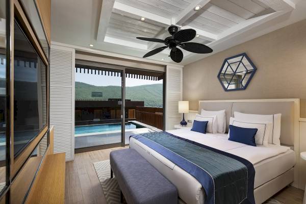 Zimmer mit Bett, Pool und Bergaussicht im Titanic Luxury Collection Bodrum