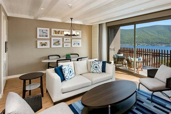 Wohnzimmer im Titanic Luxury Collection Bodrum mit Blick auf den See und Berge.