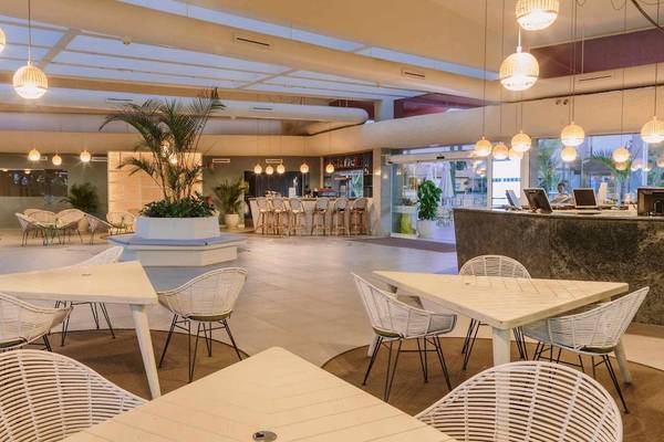 Innenbereich des Suites & Villas By Dunas Hotels mit weißen Tischen, Stühlen und Beleuchtung.