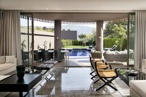 Wohnzimmer des Titanic Luxury Collection Bodrum mit Zugang zum Außenbereich und Pool.