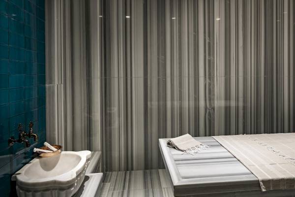 Badezimmer des Titanic Luxury Collection Bodrum mit blauen Fliesen und weißen Marmor.
