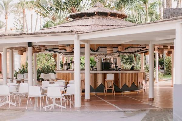 Barbereich des Suites & Villas By Dunas Hotels mit runden Tischen und Stühlen.