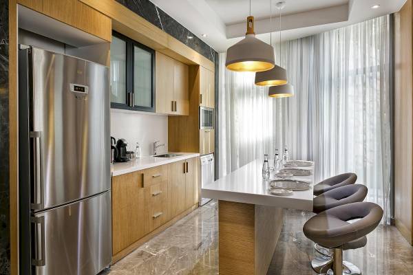 Küche des Titanic Luxury Collection Bodrum mit Edelstahlgeräten und Holzschränken.