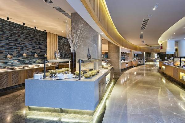 Ein beeindruckender Speisesaal des Titanic Luxury Collection Bodrum mit einer langen Theke voller Gerichte.