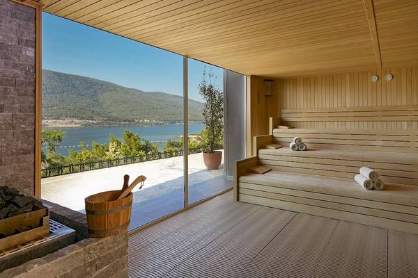 Saunaraum mit Blick auf das Meer und Bergen im Hintergrund
