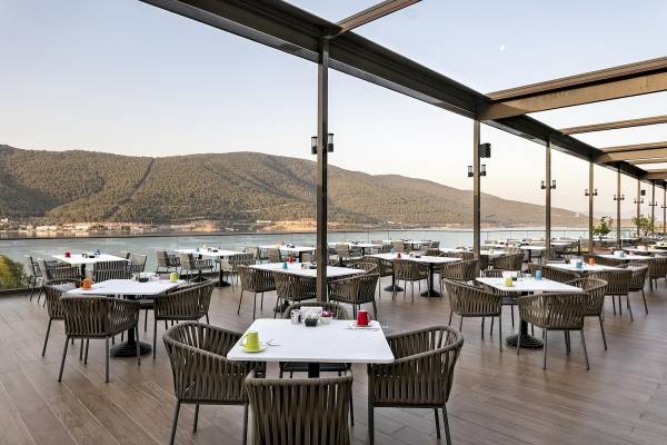 Außenterrasse des Titanic Luxury Collection Bodrum mit Blick auf das Meer und Berge.