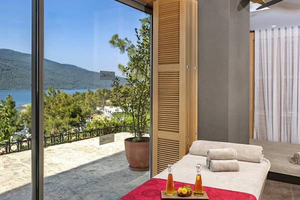 Zimmer mit Terrasse und Meerblick im Hotel Titanic Luxury Collection Bodrum mit Blick auf das Meer und die Berge.