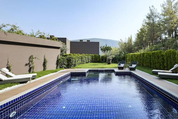 Außenpool und Terrasse des Titanic Luxury Collection Bodrum Hotels mit Sonnenliegen und Blick auf die Landschaft