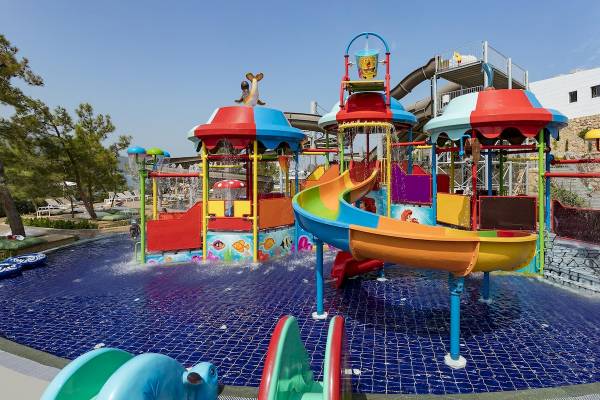 Wasserspielplatz im Titanic Luxury Collection Bodrum Hotel mit bunten Rutschen und Wasserfontaenen.