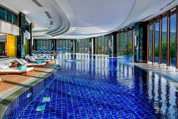 Infinity Pool im Titanic Luxury Collection Bodrum mit Loungeliegen und Panoramablick auf das Meer