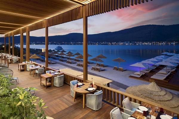 Terrasse des Titanic Luxury Collection Bodrum mit Blick auf das Meer und die Berge.