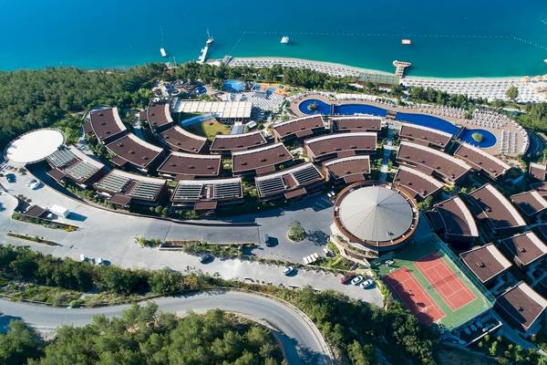Luftaufnahme des Titanic Luxury Collection Bodrum Hotels mit Blick auf das Meer, Tennisplatz und Swimmingpool.