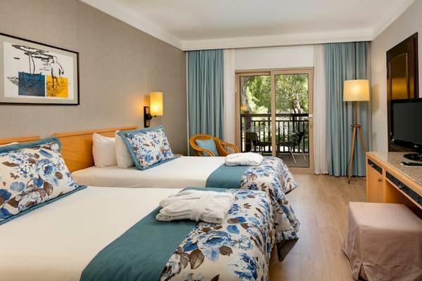 Doppelzimmer im Xanadu Resort Hotel mit zwei Betten, Fernseher, Schreibtisch und Balkon.